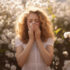 woman sneezing in field